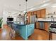 Modern kitchen with a turquoise island, stainless steel appliances, and an open layout at 4125 Coriander St, Castle Rock, CO 80109
