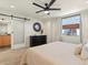 Bright main bedroom with plush carpet, neutral walls, large window with curtains, ceiling fan and en suite bath at 4125 Coriander St, Castle Rock, CO 80109