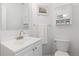 This bathroom features a white sink vanity, mirror, and commode at 9719 Burberry Way, Highlands Ranch, CO 80129