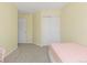 A bedroom with large closet doors and yellow walls featuring neutral carpet at 9719 Burberry Way, Highlands Ranch, CO 80129
