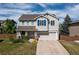 Charming two-story home featuring a two car garage, well-kept lawn, and stylish blue shutters at 9719 Burberry Way, Highlands Ranch, CO 80129