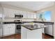 This kitchen features white cabinets, stainless appliances, dark countertops, and center island at 9719 Burberry Way, Highlands Ranch, CO 80129