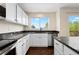 Bright kitchen with white cabinets, dark countertops and stainless steel appliances at 9719 Burberry Way, Highlands Ranch, CO 80129