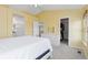 Sunlit main bedroom with yellow walls featuring a plush bed, walk-in closet, and ensuite bathroom at 9719 Burberry Way, Highlands Ranch, CO 80129