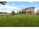 Expansive backyard with lush lawn featuring walkout basement and second story patio with scenic golf course views at 1251 Double Eagle Ct, Castle Rock, CO 80104