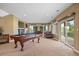 Spacious game room with a pool table, large windows, walkout patio, and comfortable seating at 1251 Double Eagle Ct, Castle Rock, CO 80104
