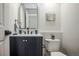 Stylish powder room features dark vanity, modern fixtures, and an oval mirror at 329 Lodgewood Ln, Lafayette, CO 80026