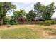 Secluded backyard featuring a grassy lawn, mature trees, and a wooden privacy fence creating a peaceful outdoor space at 12680 W 38Th Dr, Wheat Ridge, CO 80033