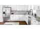 Bright kitchen features stainless steel appliances, white cabinetry, granite countertops, and mosaic backsplash at 12680 W 38Th Dr, Wheat Ridge, CO 80033