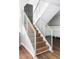 Modern staircase with wood treads, white risers, and sleek metal railing at 12680 W 38Th Dr, Wheat Ridge, CO 80033