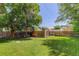 A serene backyard featuring green grass, mature trees, and a wooden fence for added privacy at 4032 Lipan St, Denver, CO 80211
