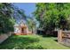 A sunny backyard view of the house, featuring a spacious lawn and a small storage shed at 4032 Lipan St, Denver, CO 80211