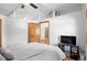 Bright bedroom featuring wood floors, white walls and ceiling, door, and media center at 3299 Lowell Blvd # 102, Denver, CO 80211