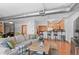 Open living space with a large sectional sofa, wood floors, and a kitchen with counter seating at 3299 Lowell Blvd # 102, Denver, CO 80211