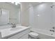 Bright bathroom featuring a white vanity, toilet, and a shower-tub combo with white tiles at 3443 N Gold Bug Ct, Aurora, CO 80019