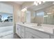 Bright bathroom features a double sink vanity with white countertops and a view to the bedroom at 3443 N Gold Bug Ct, Aurora, CO 80019