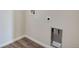 Close-up of laundry hookups with wood-look flooring and neutral wall color, ready for washer and dryer at 3443 N Gold Bug Ct, Aurora, CO 80019