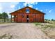 Charming barn featuring a rustic wood exterior, open doors, and a scenic view at 10325 Cherrywood Dr, Parker, CO 80138
