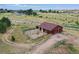 Aerial view of a barn with corrals under a cloudy blue sky at 10325 Cherrywood Dr, Parker, CO 80138