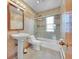Bathroom featuring a shower-tub combo with glass doors, and pedestal sink with updated tile and fixtures at 10325 Cherrywood Dr, Parker, CO 80138