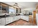 Modern kitchen features white cabinetry, an undermount sink, and access to the dining and living spaces at 10325 Cherrywood Dr, Parker, CO 80138