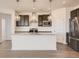 Kitchen features wood floors, stainless steel appliances, granite countertops, and dark cabinetry at 13826 Honey Hush Trl, Parker, CO 80134