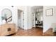 Bright hallway with hardwood floors, decorative mirror, and access to dining area with modern chandelier at 3519 Newton St, Denver, CO 80211