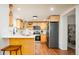 Well-lit kitchen featuring light wood cabinets, stainless steel appliances, and a breakfast bar with seating at 3519 Newton St, Denver, CO 80211