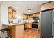 Bright kitchen featuring wooden cabinets, stainless steel appliances, quartz countertop and breakfast bar at 3519 Newton St, Denver, CO 80211