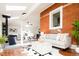 Open-concept living room featuring fireplace, brick wall, and hardwood floors at 3519 Newton St, Denver, CO 80211