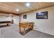 Finished basement featuring a game area with a foosball table and a unique wood plank ceiling at 8427 Chase Dr, Arvada, CO 80003