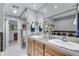 Bright bathroom with double sinks, wood cabinetry, and stylish decor for a functional space at 8427 Chase Dr, Arvada, CO 80003