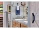 Bathroom with a barn-style door, double sinks, and a mirrored vanity with decorative accents at 8427 Chase Dr, Arvada, CO 80003