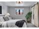 Comfortable bedroom with grey walls, a decorative ceiling fan, and a door leading to the bathroom at 8427 Chase Dr, Arvada, CO 80003