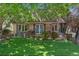 Charming exterior showcasing a manicured lawn, landscaped garden beds and covered front porch at 8427 Chase Dr, Arvada, CO 80003