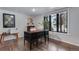Bright home office featuring a dark wood desk, hardwood floors, and a large window with a view of trees at 8427 Chase Dr, Arvada, CO 80003