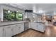 Bright kitchen with white cabinets, granite countertops, stainless steel appliances, and hardwood floors at 8427 Chase Dr, Arvada, CO 80003