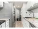 Galley kitchen with stainless steel appliances, granite countertops, and white cabinets at 11105 E Alameda Ave # 204, Aurora, CO 80012
