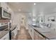 Bright kitchen boasts stainless appliances, modern white cabinets, and a large island with bar seating overlooking the living room at 2819 W 43Rd Ave, Denver, CO 80211