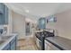 Cozy kitchen features stainless steel appliances, blue cabinets, and natural light at 2819 W 43Rd Ave, Denver, CO 80211
