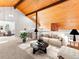 Stylish living room features vaulted wood ceiling with beams, modern decor, and comfortable seating arrangement at 11181 Main Range Trl, Littleton, CO 80127