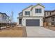 Two-story home featuring white siding, a gray garage door, and a well-manicured lawn at 9257 Truckee Ct, Commerce City, CO 80022