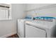 The laundry room has a modern washer and dryer set and plenty of storage with a metal rack at 9257 Truckee Ct, Commerce City, CO 80022