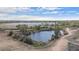 Expansive aerial view of a serene lake and lush green landscape under a bright, cloudy sky at 653 S Hoover Ave, Fort Lupton, CO 80621