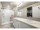 Bathroom featuring double sinks, a shower, and a walk-in closet for ultimate convenience and comfort at 653 S Hoover Ave, Fort Lupton, CO 80621