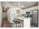 Modern kitchen with white cabinets, stainless steel appliances, and island with breakfast bar at 653 S Hoover Ave, Fort Lupton, CO 80621