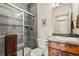 Modern bathroom with gray tile, glass-enclosed shower, and wooden vanity, providing a spa-like experience at 2714 Calmante Pl, Superior, CO 80027