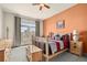 Cozy bedroom featuring a full bed, a light orange accent wall, neutral carpet, and an access door to a balcony at 2714 Calmante Pl, Superior, CO 80027