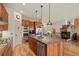 Spacious kitchen island open to the living room with a stone fireplace and hardwood floors at 2714 Calmante Pl, Superior, CO 80027