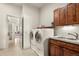 Functional laundry room with washer, dryer, sink, wooden cabinets, and tile floors at 2714 Calmante Pl, Superior, CO 80027